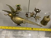 All four brass objects with measuring tape for scale