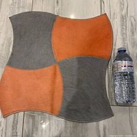 Full view of cowhide mat beside water bottle for scale