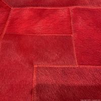 Close-up of red cowhide patchwork showing hair texture and stitching