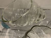 Close-up of one glass cerith seashell sculpture showing spiral ridges and wavy rim