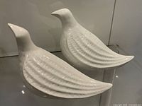 Pair of white ceramic abstract bird statues side by side