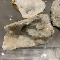 Three quartz geode halves on shelf showing crystal interiors