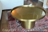 Full view of round brass pedestal table