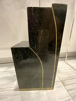 Side view of black granite pedestal with gold line and base