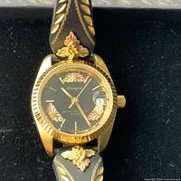 Front view of Stamper watch showing dial, bezel and 10K leaf accents