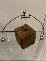 Full view of kinetic metal figure on wood cube base