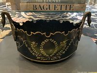 Front view showing hand-painted laurel wreath motif, scalloped rim and swan head handles