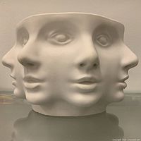 Front view showing sculpted faces on bowl