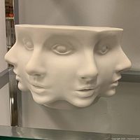 front view of white ceramic bowl showing three abstract faces