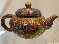 Full view left side showing dragon motif, spout, handle, lid