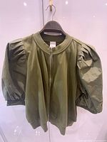 Front view of army green short-sleeve jacket on hanger