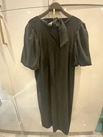 Full front view of black Anthropologie dress on hanger