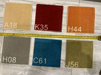 All six carpet trivets arranged, tape measure shows size