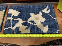 Close view single mat showing blue and off-white pattern with measuring tape indicating length