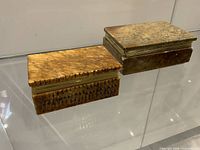 Both marble boxes closed, showing top surfaces and colors