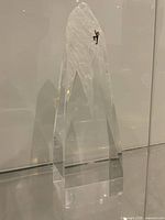 Full view of clear lucite mountain sculpture with climber