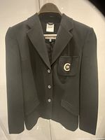 Front view of black Cerruti blazer on hanger showing buttons and logo pocket