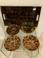 Tray, bowl, and four visible plates on glass shelf