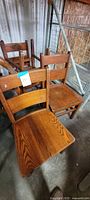 Four oak ladder-back chairs grouped together