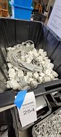 Top view of black bin filled with Apple USB adapters and Lightning cables