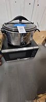 Slow cooker resting on microwave showing both appliances