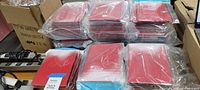 Stacks of sealed red and white iPad cases