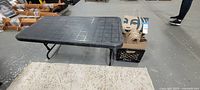 Black folding table alongside crate of Starbucks bags