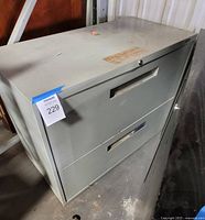 Overall view of gray metal two-drawer credenza showing drawers and handles