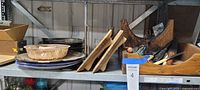 Shelf view showing serving platters, baking mold, wood caddy, knives and boards
