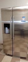 Front view of Electrolux stainless steel side-by-side refrigerator showing handles and dispenser