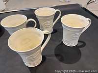 Four Belleek Claddagh mugs angled on table