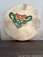 Front view of bodhran showing Celtic knot design and overall condition