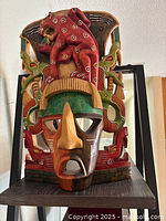 Front view of multicolour carved wooden Mexican mask