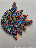 Overall view of Huichol beaded sun and moon plaque showing full beadwork