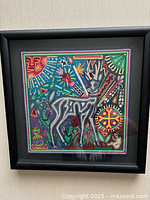 Front view of framed Huichol yarn art showing deer motif and frame