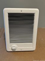 Front view of Cadet wall heater showing white grille and thermostat knob