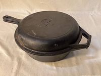 Skillet inverted on deep pan showing nesting fit and Cuisinel logo