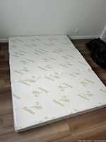 Tri-fold mattress laid flat showing bamboo print cover