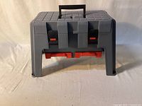 closed plastic step-stool toolbox front view showing two red lower drawers