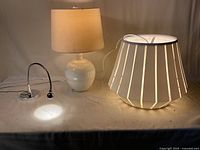 Group view of three lamps: ceramic table lamp, slatted pendant shade, chrome desk lamp