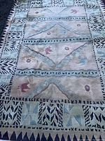 Full view of Tibetan wool rug laid out showing overall pattern and fringe