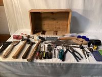 Overall lot view with wooden toolbox and array of hand tools