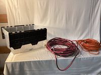 Overall view: two coiled extension cords and plastic bin