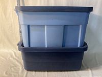 Two stacked blue Rubbermaid totes showing relative heights