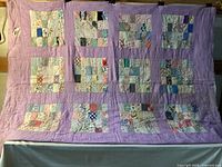 Full view of purple-sashed quilt hung for display