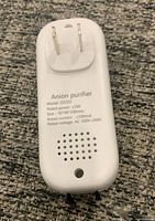 Back of air purifier showing plug prongs and specifications text