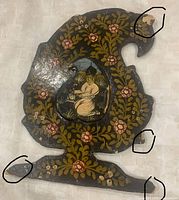 Front view, shutter closed showing painted figure and floral motif, paint chips visible