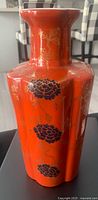 Full view of red porcelain vase showing floral decoration