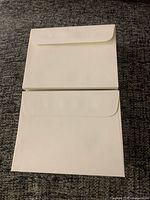 front and back of two envelopes showing flap style and colour