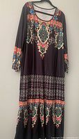 Front view of multicolour boho print midi dress hanging